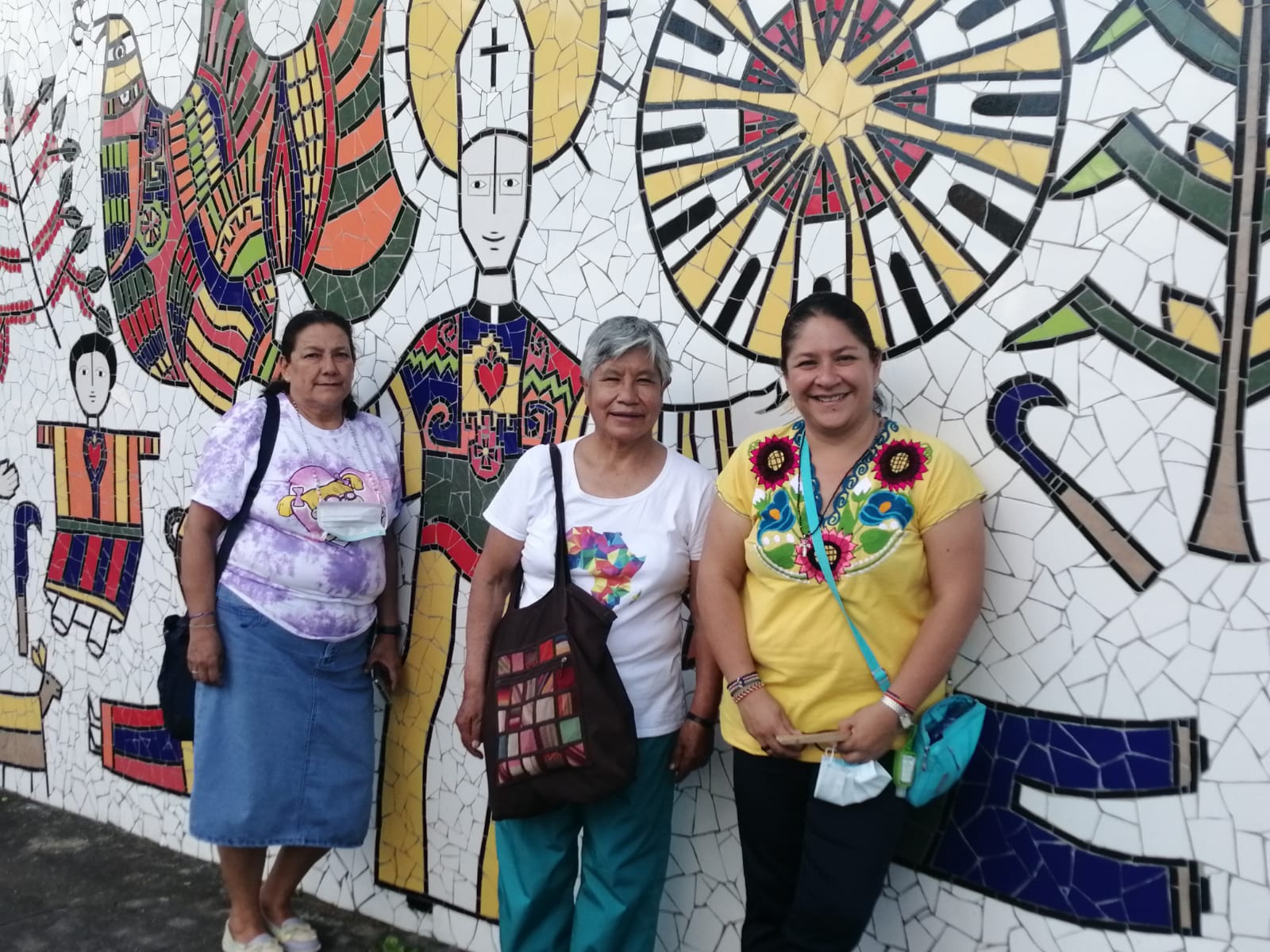 Sr. Zaira Gutierrez, right in yellow shirt, poses for a photo with other Apostolics of the Heart of Jesus, in front of art depicting St. Oscar Romero in San Salvador in November 2022. She said the life of St. Romero influenced her vocation and commitment to the poor. (Courtesy of Apostolics of the Heart of Jesus) 