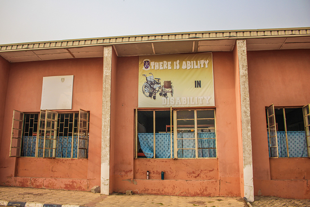 A banner reads, "There is ability in disability," on a wall behind one of the classroom blocks at St. Louis Nursery and Primary School. (GSR photo/Valentine Benjamin)