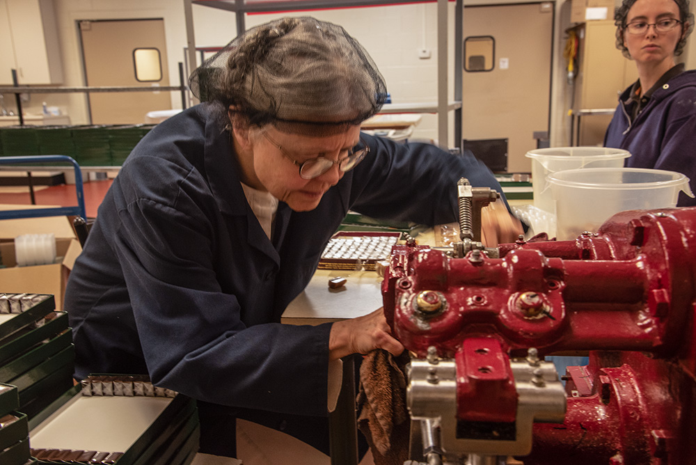 Trappistine Sr. Kathleen O'Neill of Our Lady of the Mississippi Abbey near Dubuque, Iowa, tends to one of the candy-making machines. (Courtesy of Bill Witt)