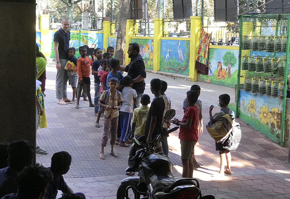 Salesian Father Prasad (black shirt in the middle), the director of BOSCO Mane, conducts a game for the center's boys with an Austrian intern.  (Thomas Scaria)