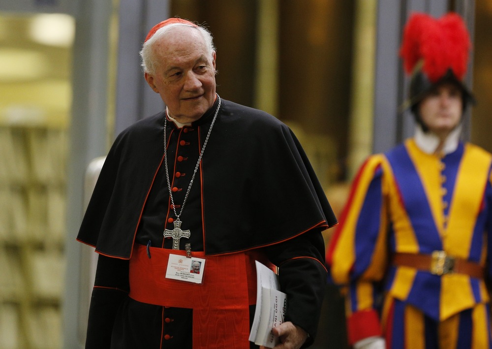 Cardinal Marc Ouellet. Cardinal pictures walking, with Swiss Guard in background.
