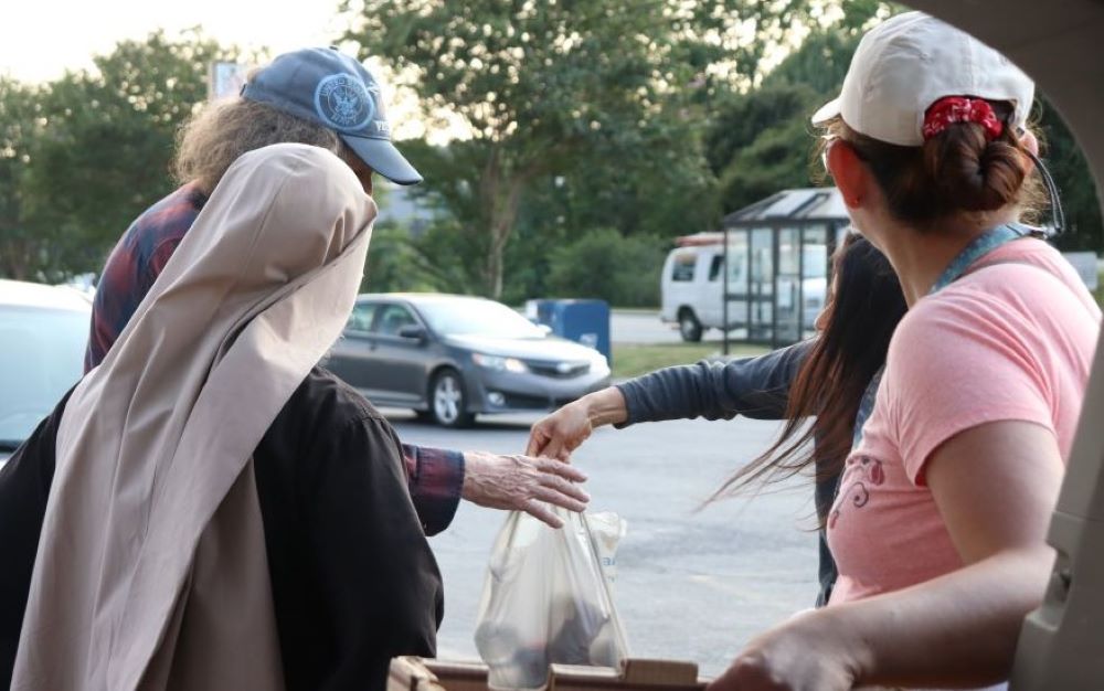 Community members accept food from members of the Sisters Poor of Jesus Christ in Cedartown, Georgia. 