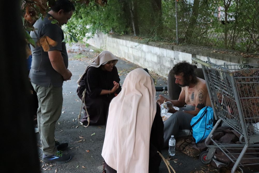 Sisters Poor of Jesus Christ pray with a man during their street ministry in Cedartown, Georgia.