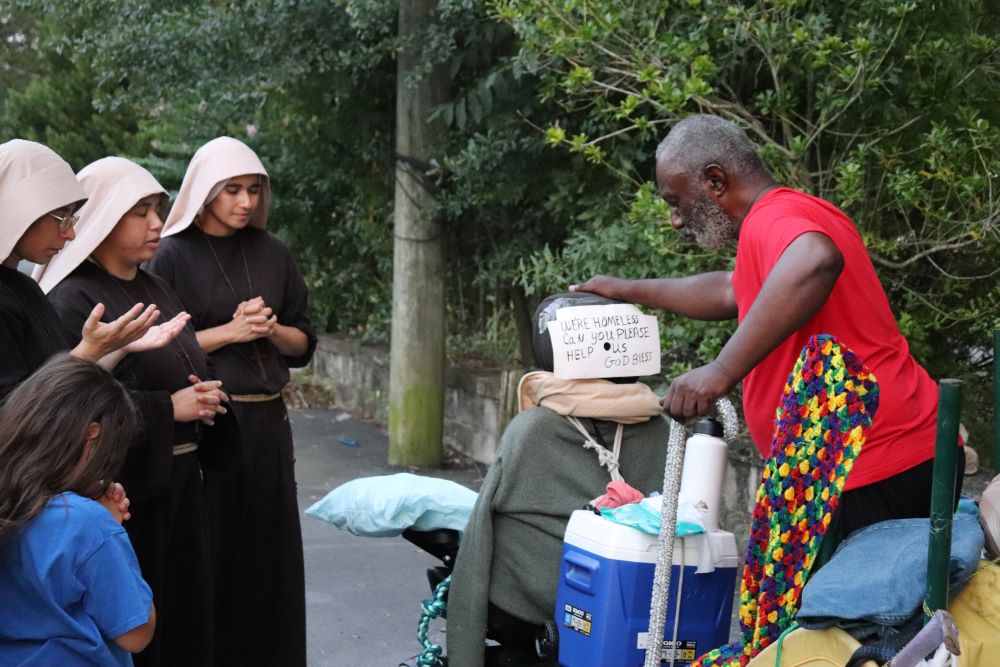 Sisters Poor of Jesus Christ pray with a man during their street ministry in Cedartown, Georgia.