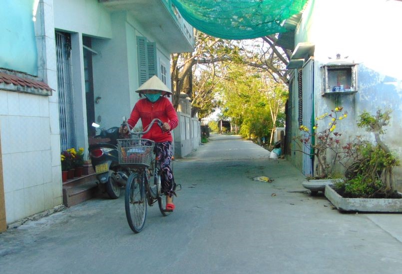 A woman rides her bicycle on a cement road on March 24 in Huong Tra district of Thua Thien Hue province, Vietnam.