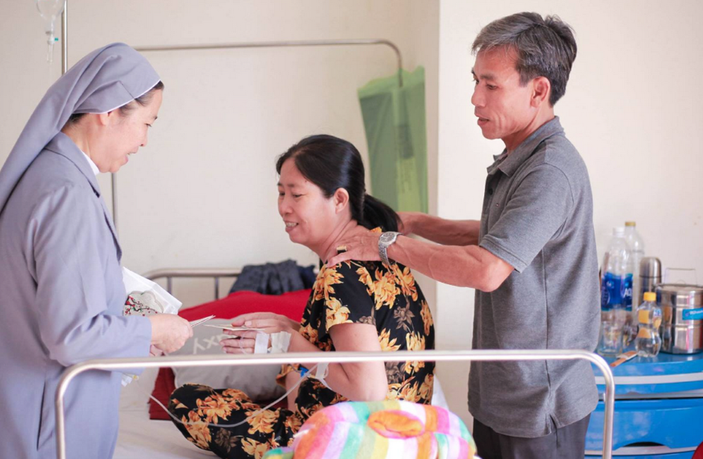 Sr. Anna Dang Thi Nhung visits and gives gifts to a patient at her house in Hue on March 10, 2024.