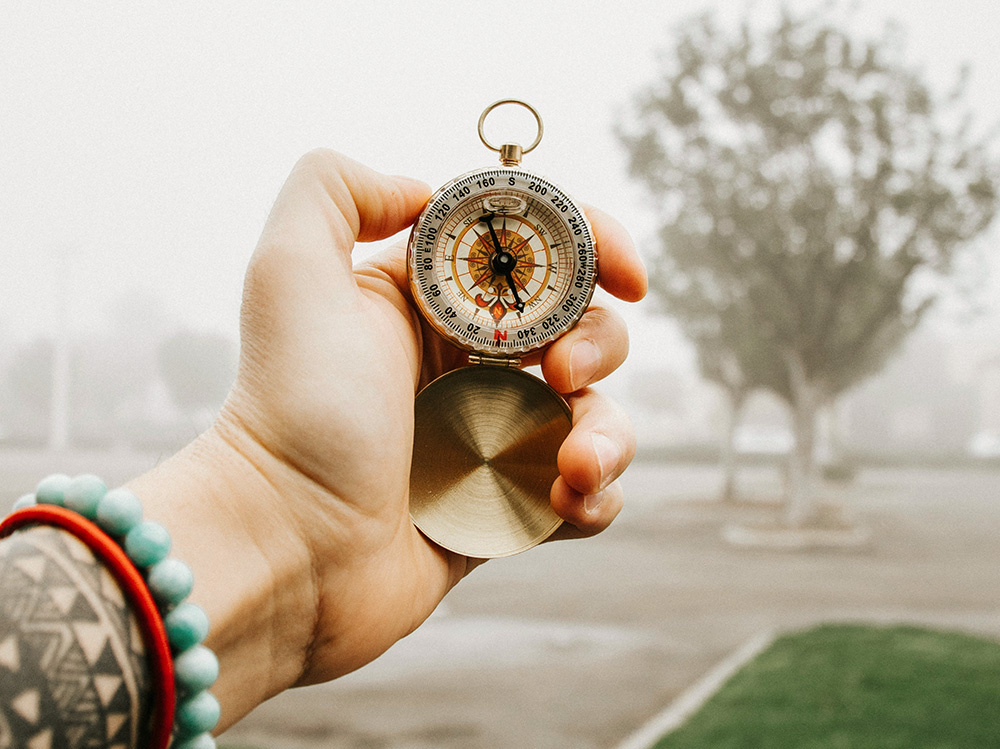 Hand holding a compass (Unsplash/Frames For Your Heart)