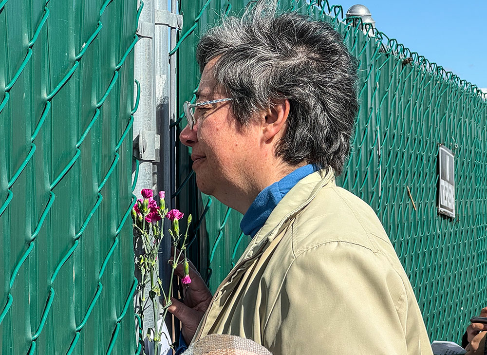 La Hna. Clara Malo Castrillón, provincial de la Sociedad del Sagrado Corazón de México, se enfoca para ver, a través de una abertura, unas tumbas separadas por una valla del resto del cementerio Terrace Park en Holtville, California, durante una visita el 7 de febrero. Religiosas de varias congregaciones pasaron a rezar y tirar flores por encima de la valla que separa la sección donde se encuentran los restos mortales de migrantes anónimos. (Foto: Rhina Guidos/GSR) 