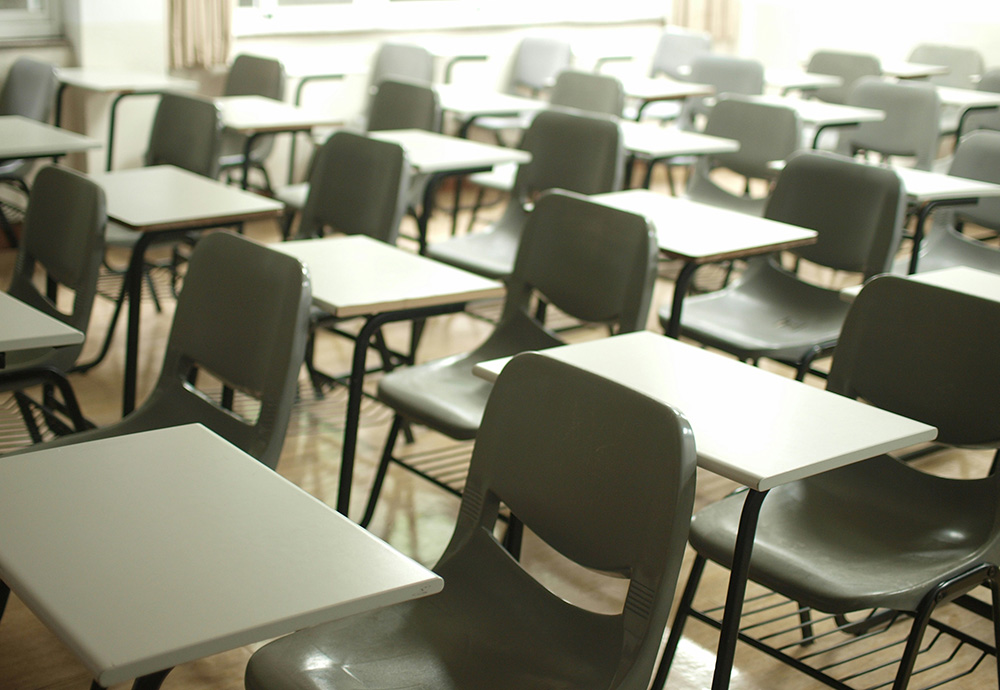 Rows of school desks and chairs (Unsplash/MChe)