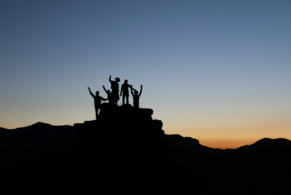 Silhouette of a group of people on a mountain (Unsplash/Natalie Pedigo)