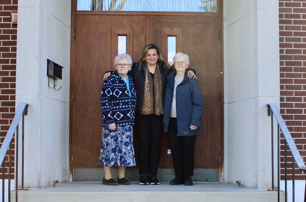 Srs. Gabrielle Servant and Pierette Bertrand and their secretary, Marie Hossepian, stand at the front door of their congregation in Montreal.