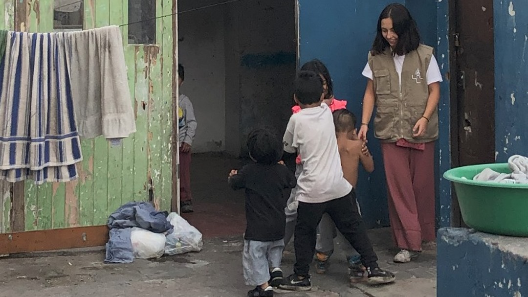 Una voluntaria de la pastoral social juega con unos niños en una visita a una familia en Lima. (Foto: cortesía Begoña Costillo)