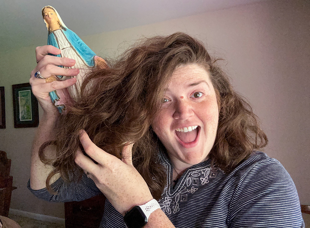 Mercy Sr. Kelly Williams pulls a statue of the Virgin Mary out from her hair during a "Saturday Sister Surprises" video. (Courtesy of Kelly Williams)