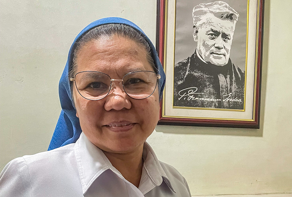 Salvatorian Sr. Mary Adeline Abamo poses next to a portrait of the founder of the Society of the Divine Savior, Blessed Francis Mary of the Cross Jordan. (Tonette Orejas)