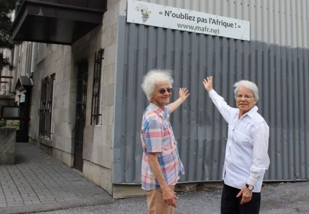 Hermanas Rita Toutant, a la izquierda, y Monique Bonnefoy, de las Hermanas Misioneras de Nuestra Señora de África Las hermanas Rita Toutant, a la izquierda, y Monique Bonnefoy, de las Hermanas Misioneras de Nuestra Señora de África, señalan un cartel que reza: "No olviden a África", en el lateral de la casa misionera donde viven en Montreal. (Foto: GSR/Joanna Kozakiewicz)