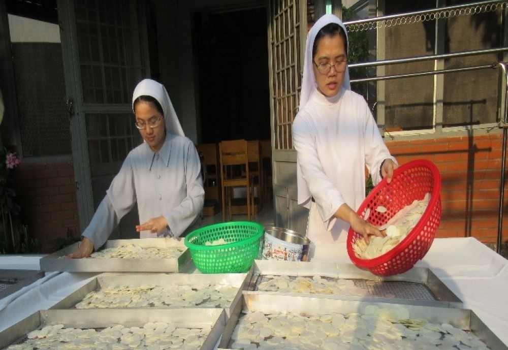 Sisters make Communion wafers. Sisters make Communion wafers.