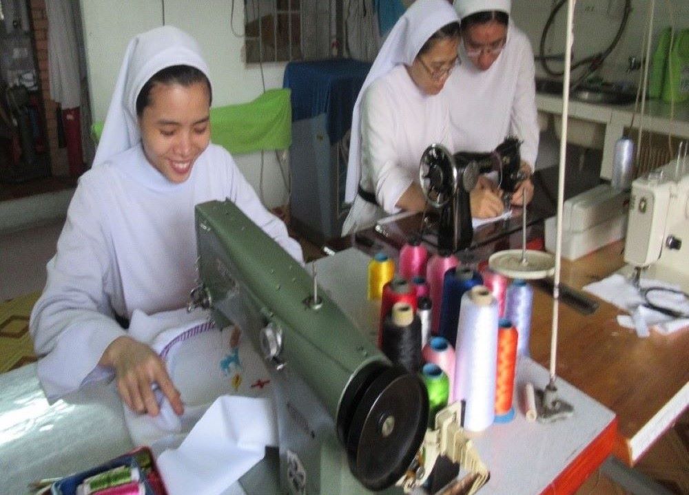 Sisters work at sewing machines. Sisters work at sewing machines.