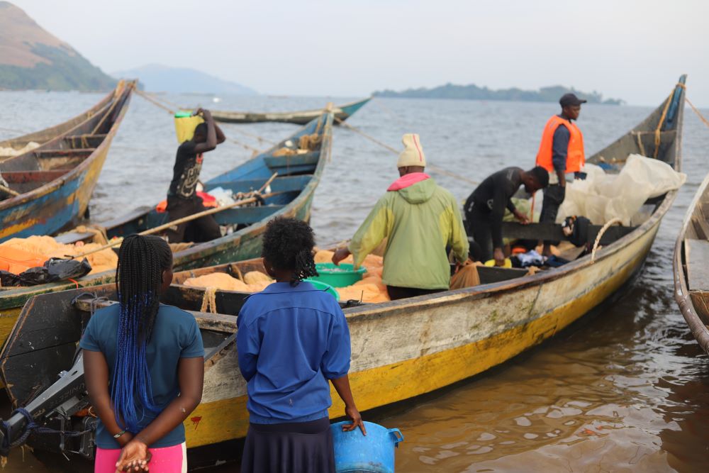 Young women on the shores of Lake Victoria in western Kenya are buying fish as boats return from fishing on July 17. Young women on the shores of Lake Victoria in western Kenya are buying fish as boats return from fishing on July 17.