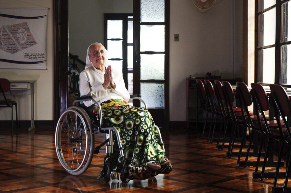 Sister Inah Canabarro, Brazil, Feb. 16, 2024. The sister sits in wheelchair holding up prayer hands.