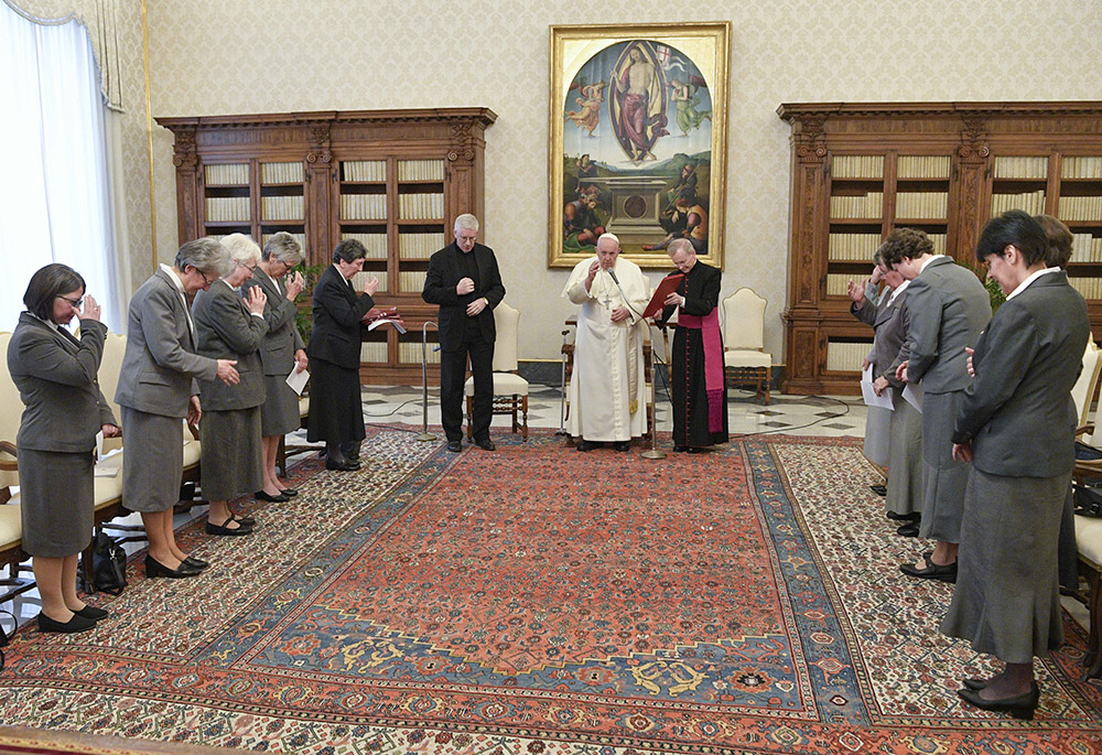 Pope Francis prays with a group of Sisters of Social Service in the library of the Apostolic Palace at the Vatican Jan. 20, 2023, to mark the 100th anniversary of the founding of the order. (CNS/Vatican Media)