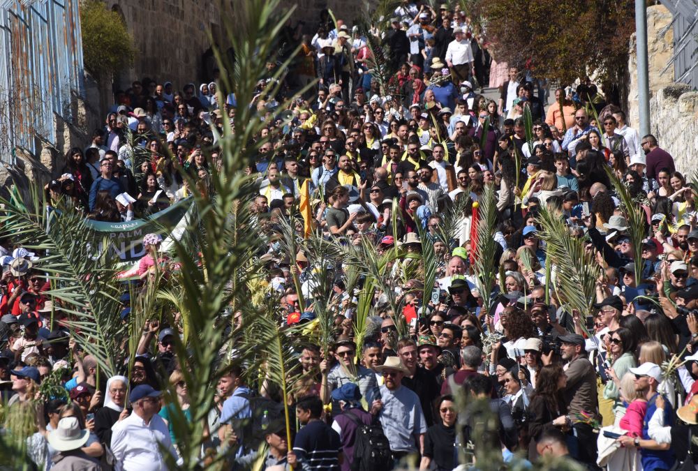 Christians carry palm fronds as they walk the traditional path that Jesus took on his last entry into Jerusalem during the Palm Sunday procession on the Mount of Olives in Jerusalem April 2, 2023. 
