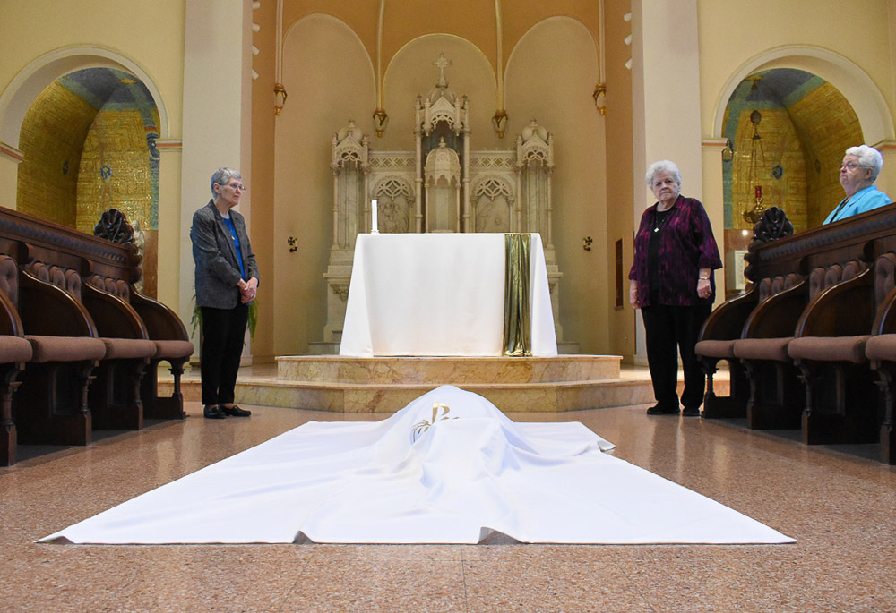 Sr. Helga Leija lies prostrate on the floor and is covered with the pall as a sign of her mystical burial with Christ. As all creation was made new during the time of our Lord’s rest in the tomb, so also is the newly professed made new as the community prays over her that she may live a full and fruitful monastic life. (Courtesy of Helga Leija)
