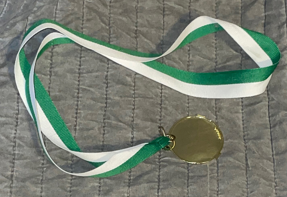 A photo of a medal with a green and white ribbon Photo of a medal with a green and white ribbon