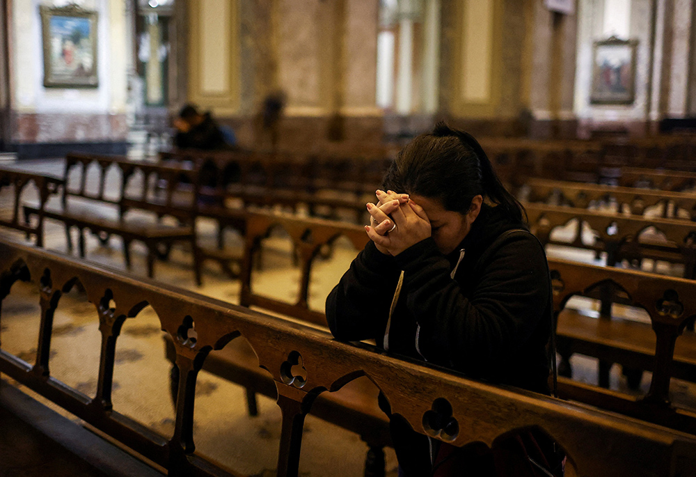 A woman prays inside Buenos Aires' Metropolitan Cathedral in Buenos Aires, Argentina, April 21, 2025, after the death of Pope Francis was announced by the Vatican. Francis, formerly Argentine Cardinal Jorge Mario Bergoglio, died April 21 at age 88. (OSV News/Reuters/Agustin Marcarian)