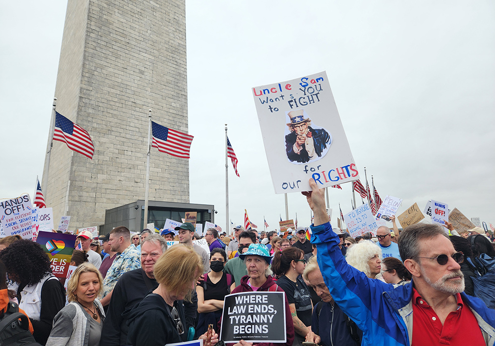 Demonstrators stand at the foot of the Washington Monument on the National Mall during the April 5 "Hands Off!" demonstration in Washington, D.C. (GSR photo/Chris Herlinger)