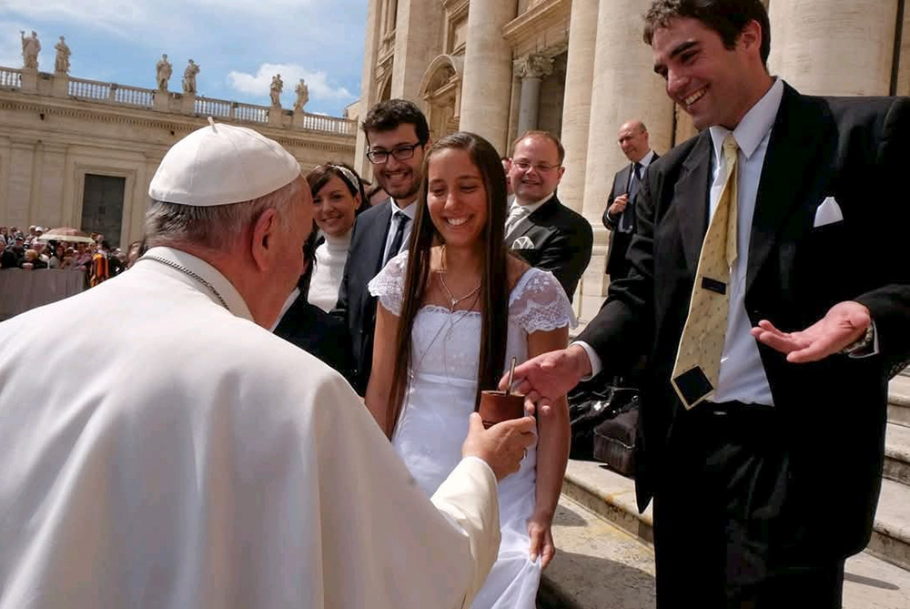 María Guadalupe Baulos and Bruno Maltese, both of Buenos Aires, share mate, the national drink of Argentina, with Pope Francis after receiving a blessing for newlyweds at the Vatican April 29, 2015. Even though the pope never returned to Argentina, those from his home country always made the effort to go see him, said the bride's mother, Liliana Fernández. (Courtesy of Liliana Fernández)