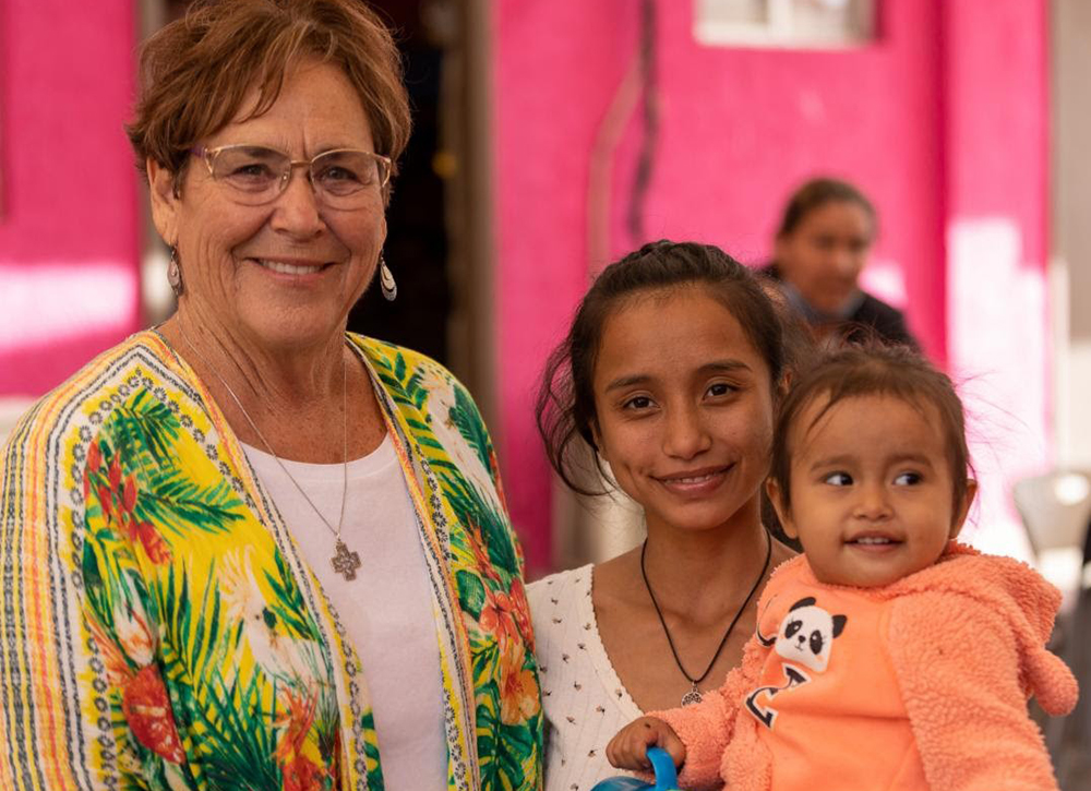 Sr. Suzanne Jabro, a member of the Sisters of St. Joseph of Carondelet, stands with a woman and child living at the Cobina Posada del Migrante Shelter in Mexicali, Mexico, which Jabro supplies with essentials through her nonprofit Border Compassion. (Courtesy of Border Compassion)