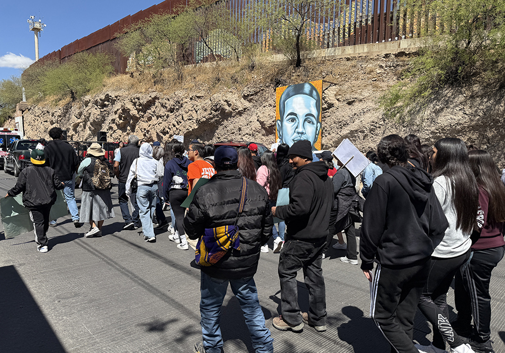 A Via Crucis procession held Saturday along the border in Nogales, Mexico, passes by a portrait of José Antonio Elena Rodriguez, a teenager who was killed in 2012 by a U.S. Border Patrol agent who was standing on the American side when he shot through a border fence at a group he said were throwing rocks at him. The agent was later acquitted. (Anita Snow)