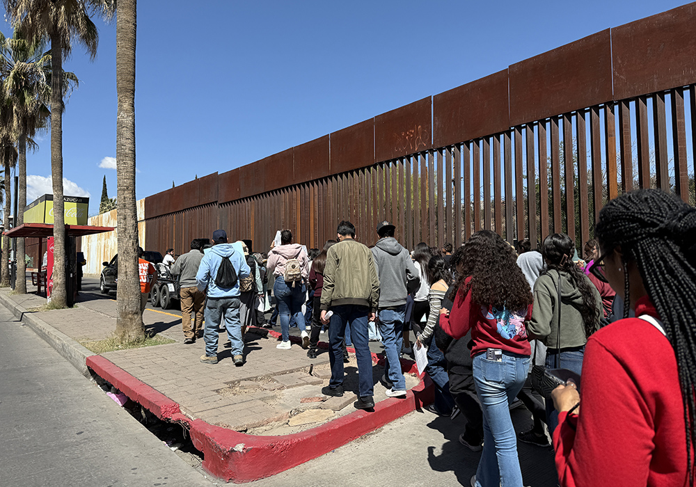A Via Crucis procession passes by the border wall April 5 in Nogales, Mexico, in a nod to the sufferings of migrants. (Anita Snow)
