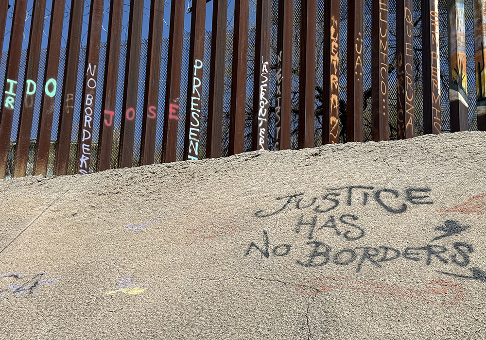 Pro-migrant messages spray-painted along the border wall that participants passed during a symbolic Via Crucis in Nogales, Mexico, on April 5 (Anita Snow)