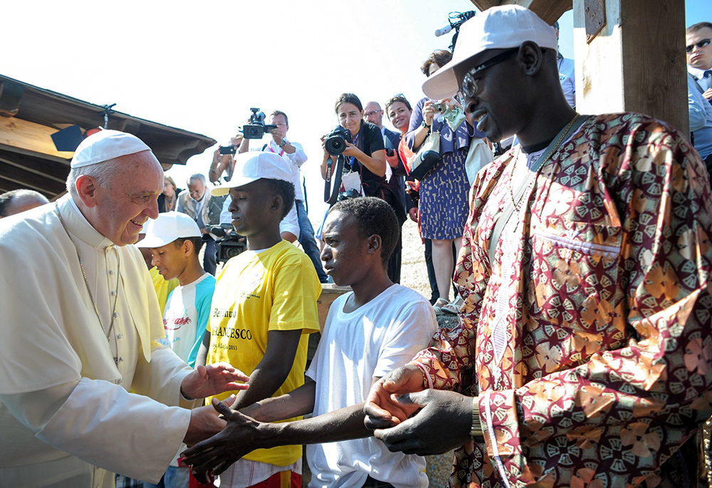 Pope Francis greets immigrants at the port in Lampedusa, Italy, in this file photo from July 8, 2013. During his visit, the pontiff urged people not to be part of the "globalization of indifference" to the plight of the millions worldwide who are immigrants and refugees. (CNS/L'Osservatore Romano via CPP)