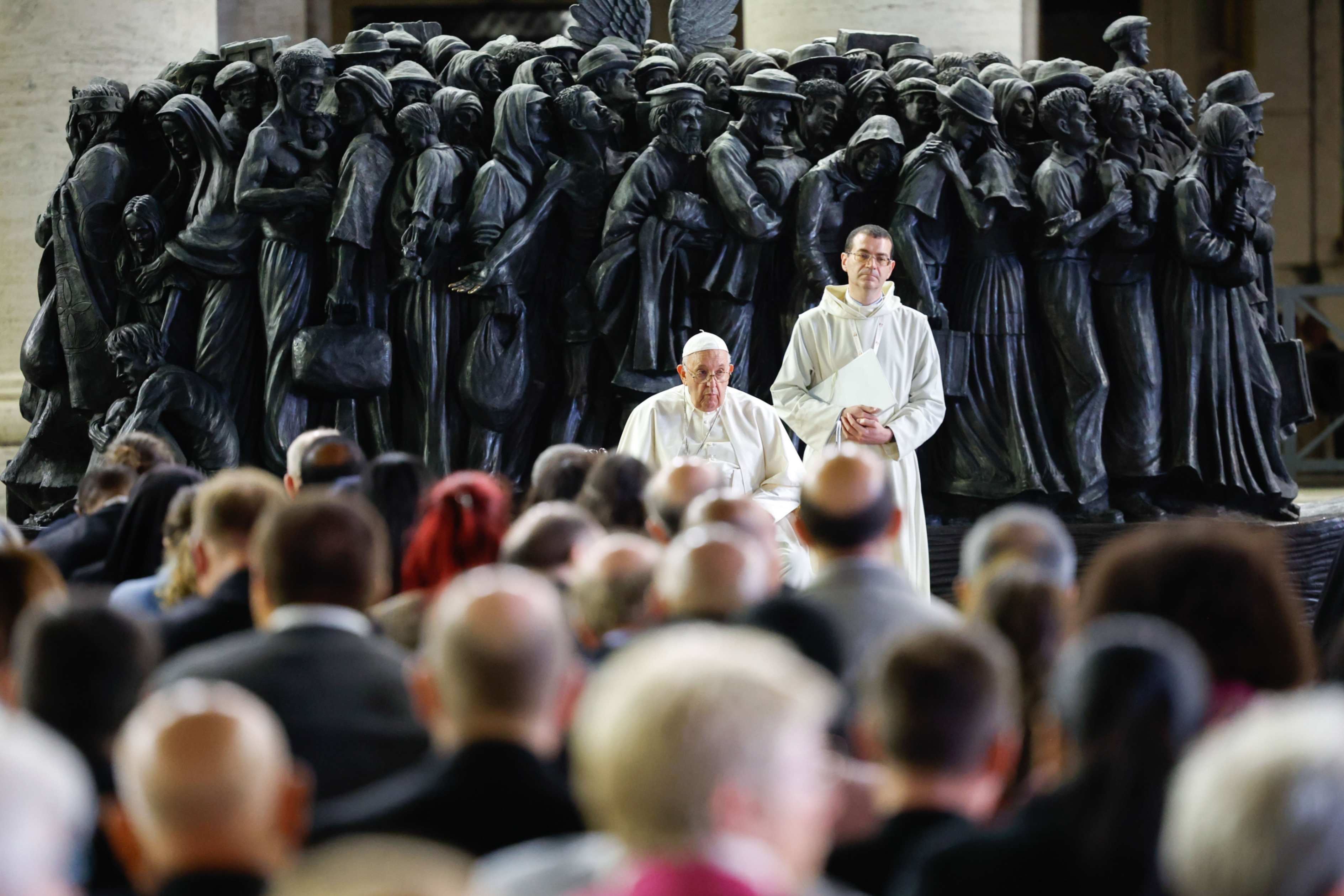 Pope Francis shares a moment of silence with members of the assembly of the Synod of Bishops at the end of a prayer for migrants and refugees in St. Peter's Square at the Vatican Oct. 19, 2023. The service took place around "Angels Unawares," a sculpture by Canadian Timothy Schmalz, depicting a boat with 140 figures of migrants from various historical periods and various nations. (CNS/Lola Gomez)