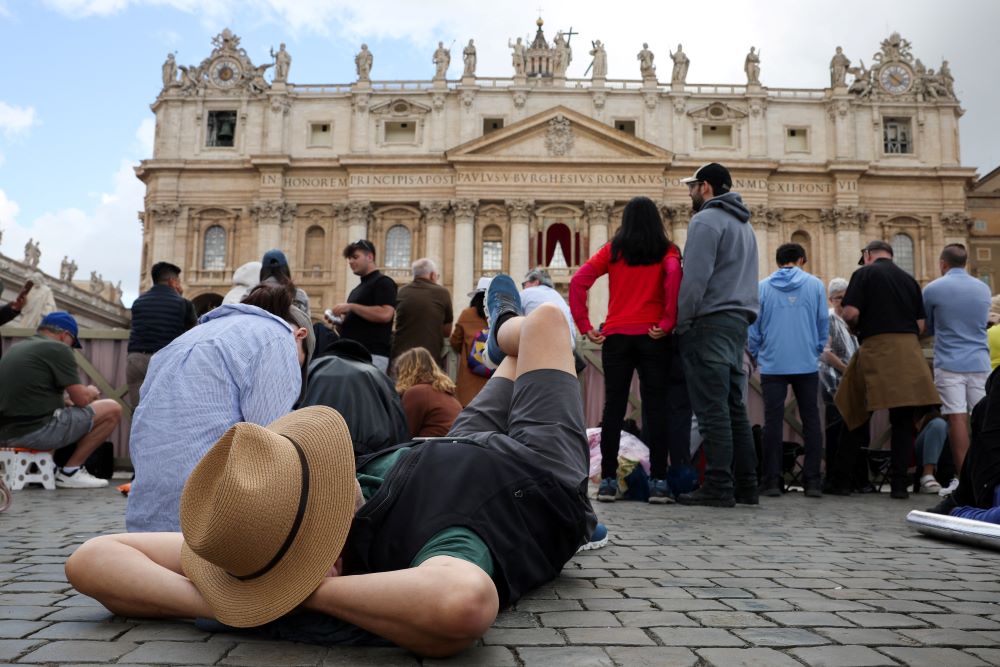 A person rests in St. Peter's Square at the Vatican May 8, 2025, the second day of the conclave to elect the new pope. (OSV News/Reuters/Marko Djurica)
