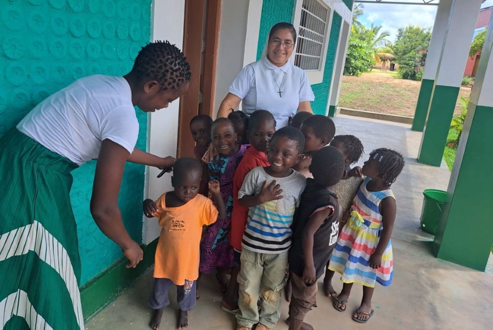 Sr. Aurora Jacinto stands with children outside a classroom made of plastic bottles. Sr. Aurora Jacinto stands with children outside a classroom made of plastic bottles.