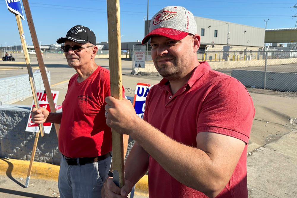 Striking United Auto Workers member Chris Jedrzejek, right, and his father picket outside Ford Motor Co.'s Michigan Assembly Plant Oct. 2, 2023, in Wayne, Mich. Striking United Auto Workers member Chris Jedrzejek, right, and his father picket outside Ford Motor Co.'s Michigan Assembly Plant Oct. 2, 2023, in Wayne, Mich.