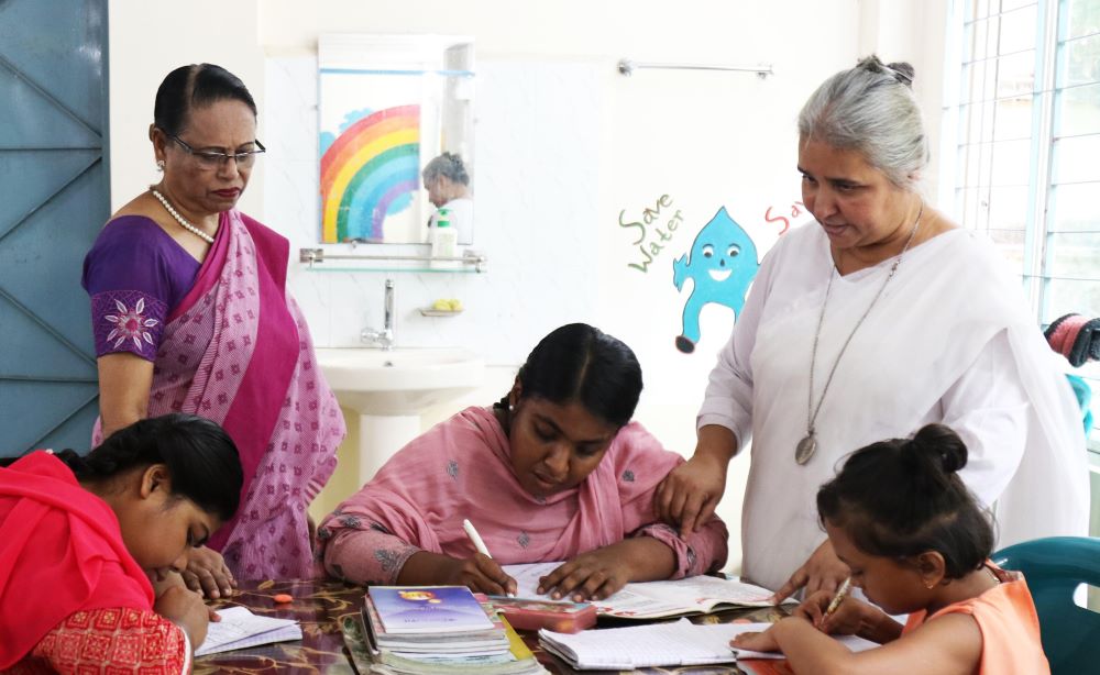 Sr. Nita Rozario with children at table Sr. Nita Rozario with children at table