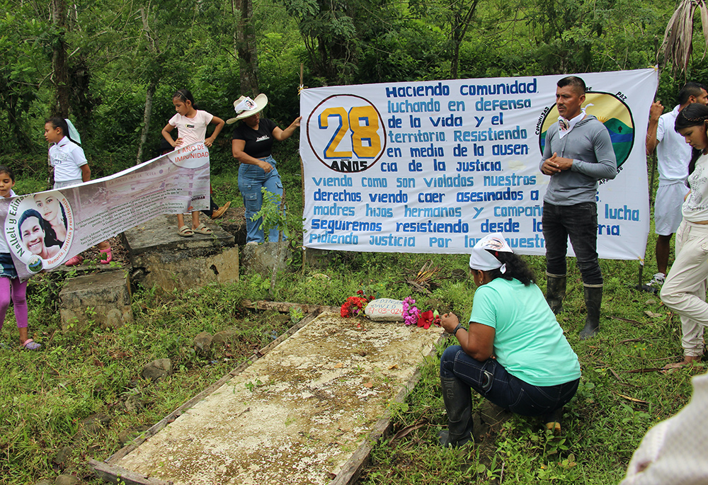 Community leader Germán Gracianos, right, speaks at the gravesite of Édinson David in La Esperanza, Colombia, on March 23, 2025. The Peace Community of San José de Apartadó, Colombia, began its 28th anniversary celebration with a pilgrimage to the gravesites of two members killed in 2024. (Tracy L. Barnett)