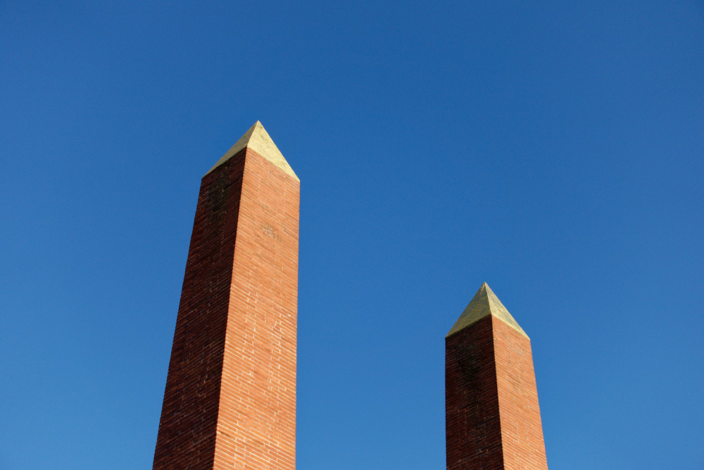 2 pillars 2 brick-red pillars against a very blue sky