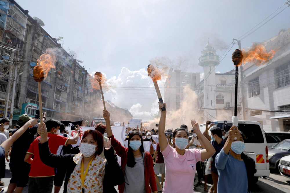 A group of women hold torches as they protest against the military coup in Yangon, Myanmar, July 14, 2021. People from all walks of life in Myanmar observed a "silent strike" in defiance of the ruling junta Feb. 1, 2022, the anniversary of the military coup. (CNS photo/Reuters) A group of women hold torches as they protest against the military coup in Yangon, Myanmar, July 14, 2021. People from all walks of life in Myanmar observed a "silent strike" in defiance of the ruling junta Feb. 1, 2022, the anniversary of the military coup. (CNS photo/Reuters)