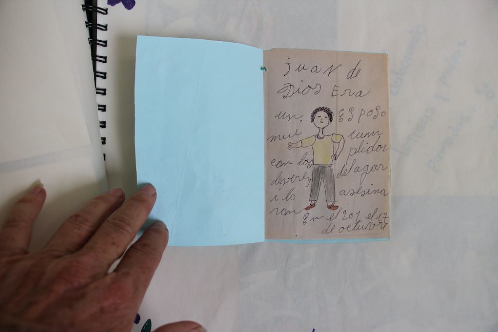 Sr. Rosa Cadavid holds a booklet a woman made to honor a devoted husband, Juan de Dios. Sr. Rosa Cadavid holds a booklet a woman made to honor a devoted husband, Juan de Dios.