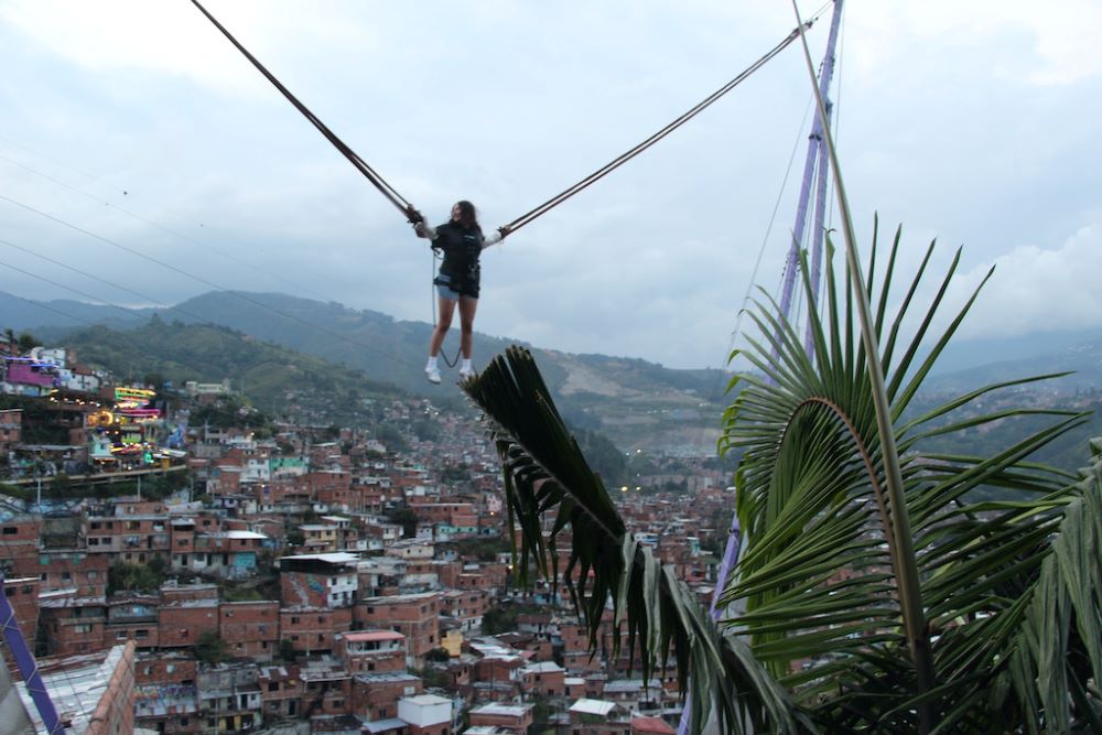 A tourist bounces on a bungee trampoline on a boardwalk-like strip at the top of the hill in Medellín, Colombia. A tourist bounces on a bungee trampoline on a boardwalk-like strip at the top of the hill in Medellín, Colombia.