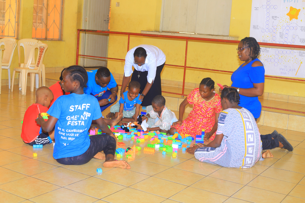 Children play with building blocks Children gather on the tiled floor for a group building activity led by caregivers and sisters. (GSR photo/Doreen Ajiambo)