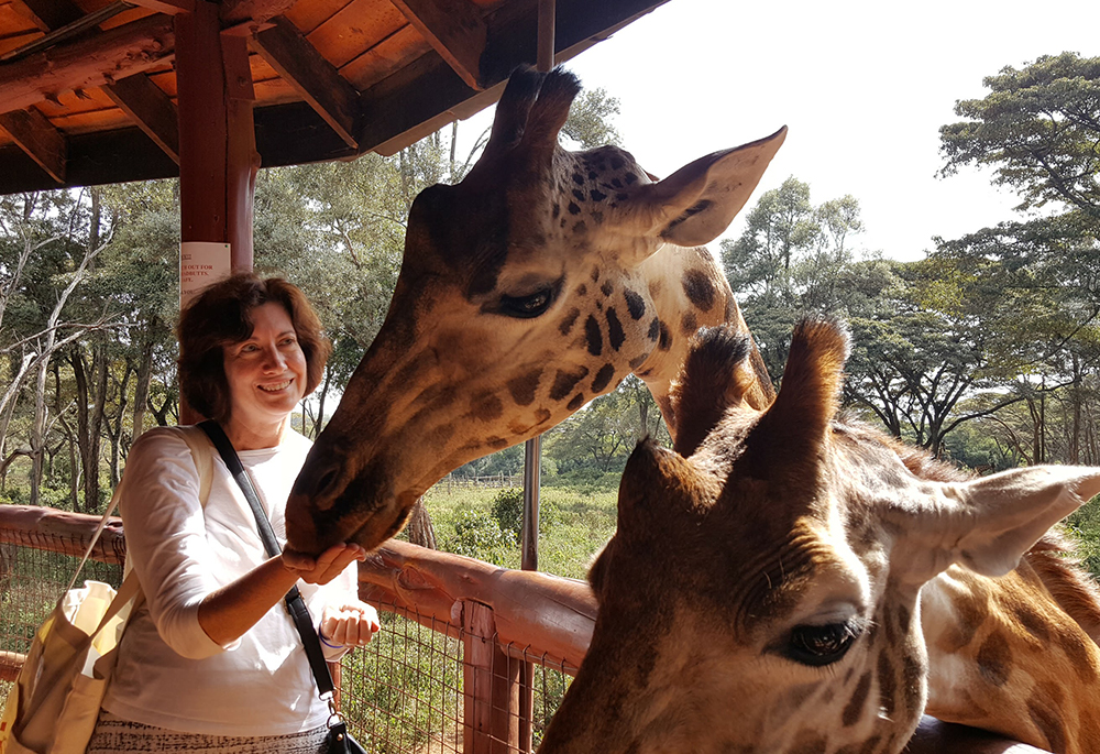 Trips abroad included some time to see local sites and scenery.  Gail DeGeorge is pictured at the Giraffe Centre in Nairobi, Kenya, in October 2016 (Courtesy of Gail DeGeorge) 
