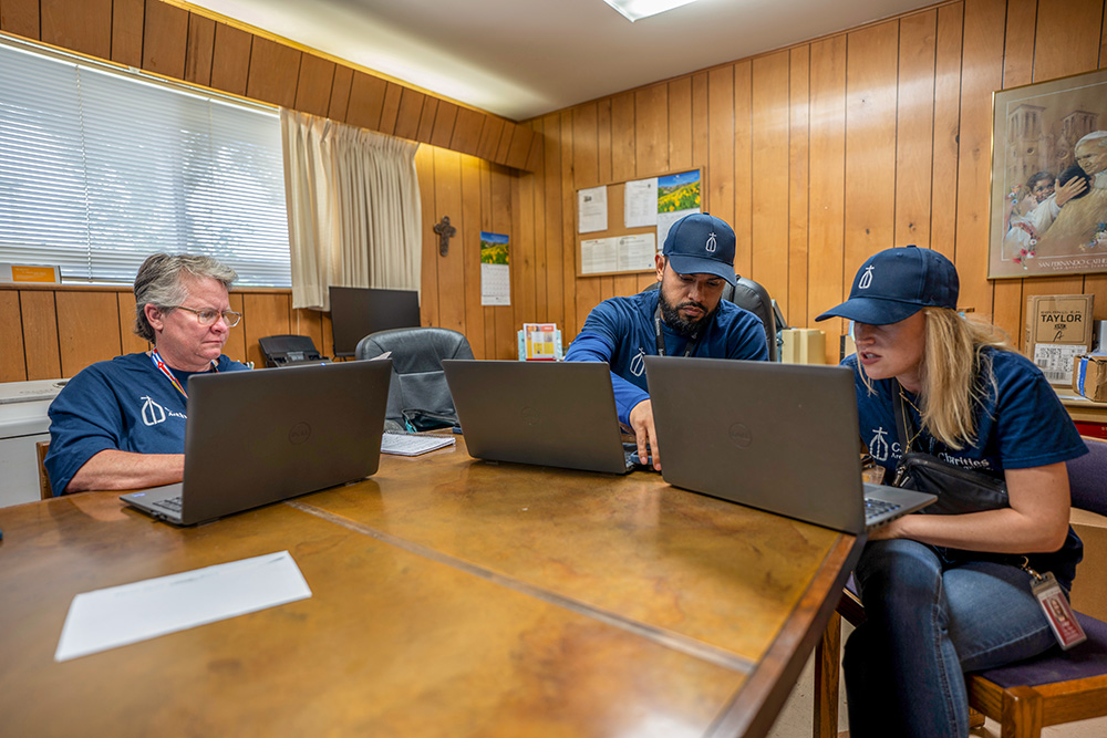 Daughter of Charity Sr. Denise LaRock works alongside Catholic Charities colleagues Omar Davila, senior director for family self-sufficiency, and Lizzy Perales, vice president of programs, in Kerrville, Texas, as they coordinate response efforts for victims of the July 4-5 flash flooding here. (GSR photo/Gregg Brekke)