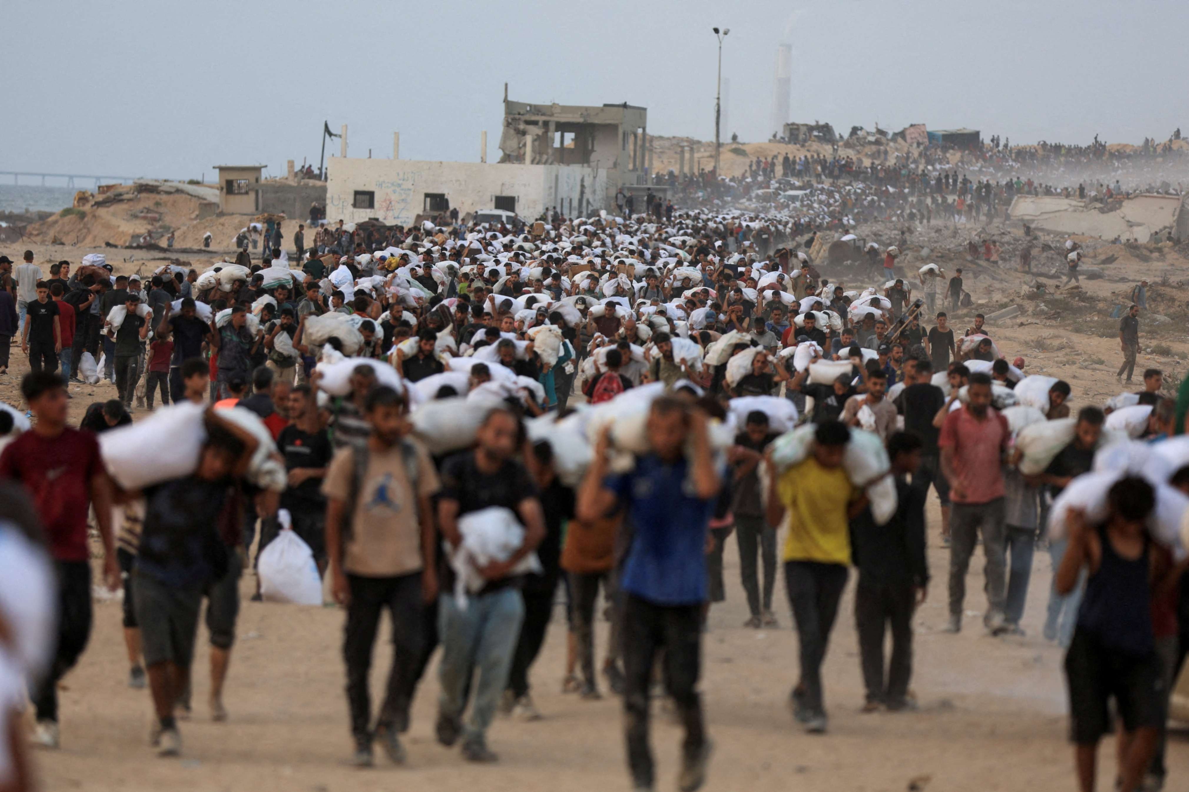 Palestinos transportan suministros de ayuda humanitaria que ingresaron a Gaza en camiones a través de Israel, en Beit Lahia, al norte de la Franja de Gaza, el 29 de julio de 2025. A pesar de las enormes dificultades, Catholic Relief Services (CRS) y sus socios locales han logrado distribuir ayuda a 1.7 millones de personas en Gaza desde 2023, según nuevos datos. (Foto: OSV News/Dawoud Abu Alkas, Reuters)