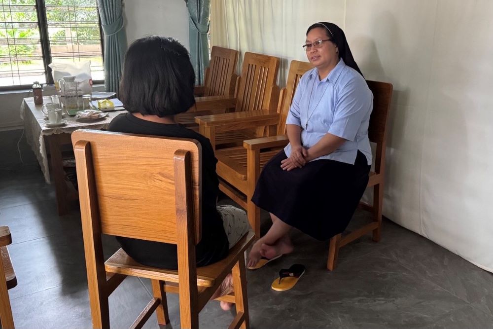A nun faces a girl, both sitting in chairs, during counseling session. A nun faces a girl, both sitting in chairs, during counseling session.